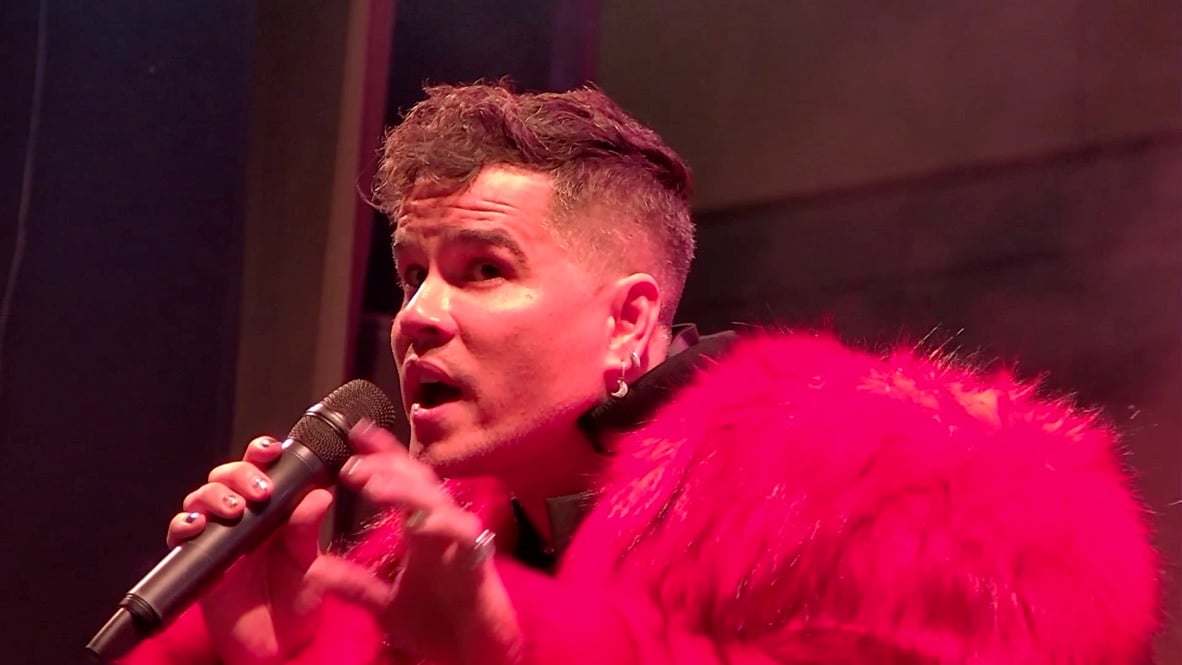 Lui da Motta close-up, singing into the mic in red fur.
